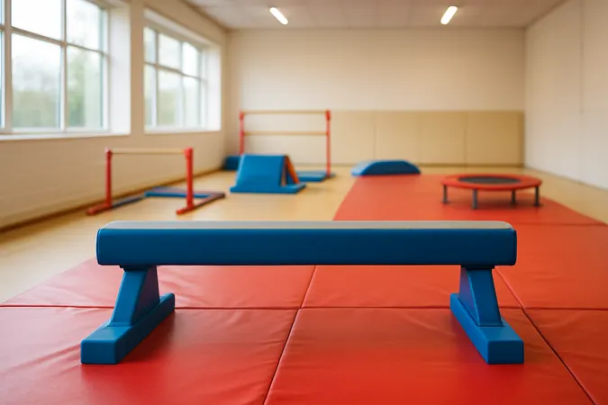 A low padded balance beam set up in a bright indoor gymnastics gym for a toddler class, toddler gymnastics Surrey, for parents and carers of children under 5.
